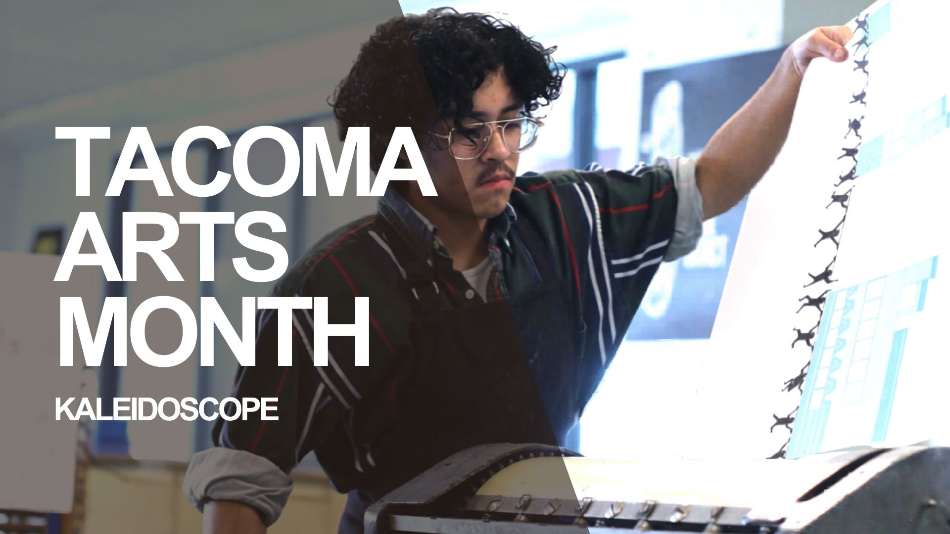 A young person holds up a print during a demonstration of printmaking techniques at Kaleidoscope the opening celebration of Tacoma Arts Month.